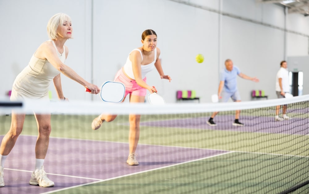 Senior woman and younger woman playing pickleball