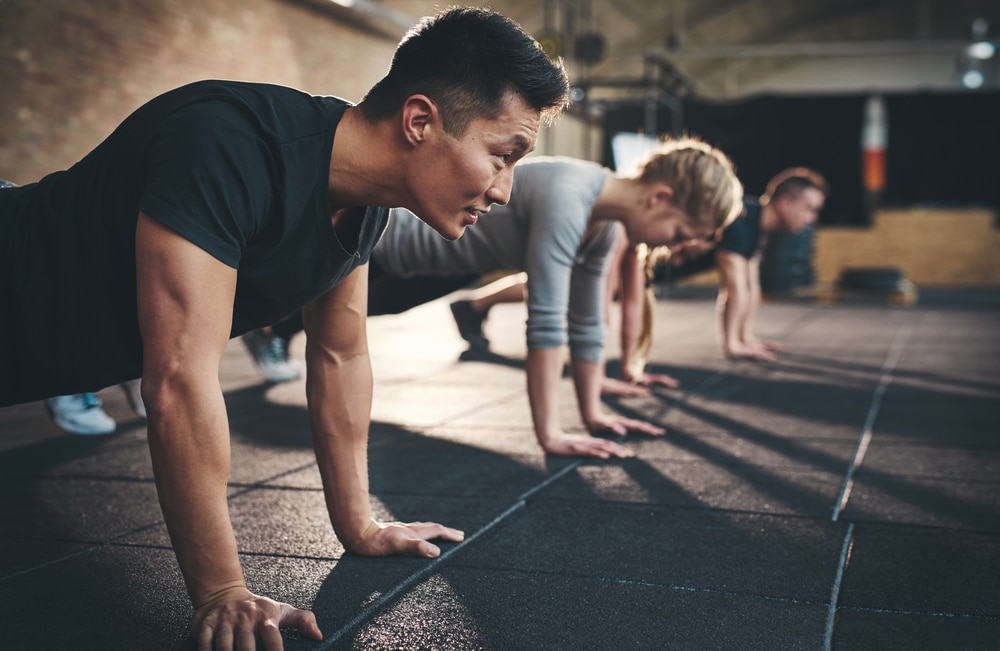 People in a line doing planks during group fitness class.